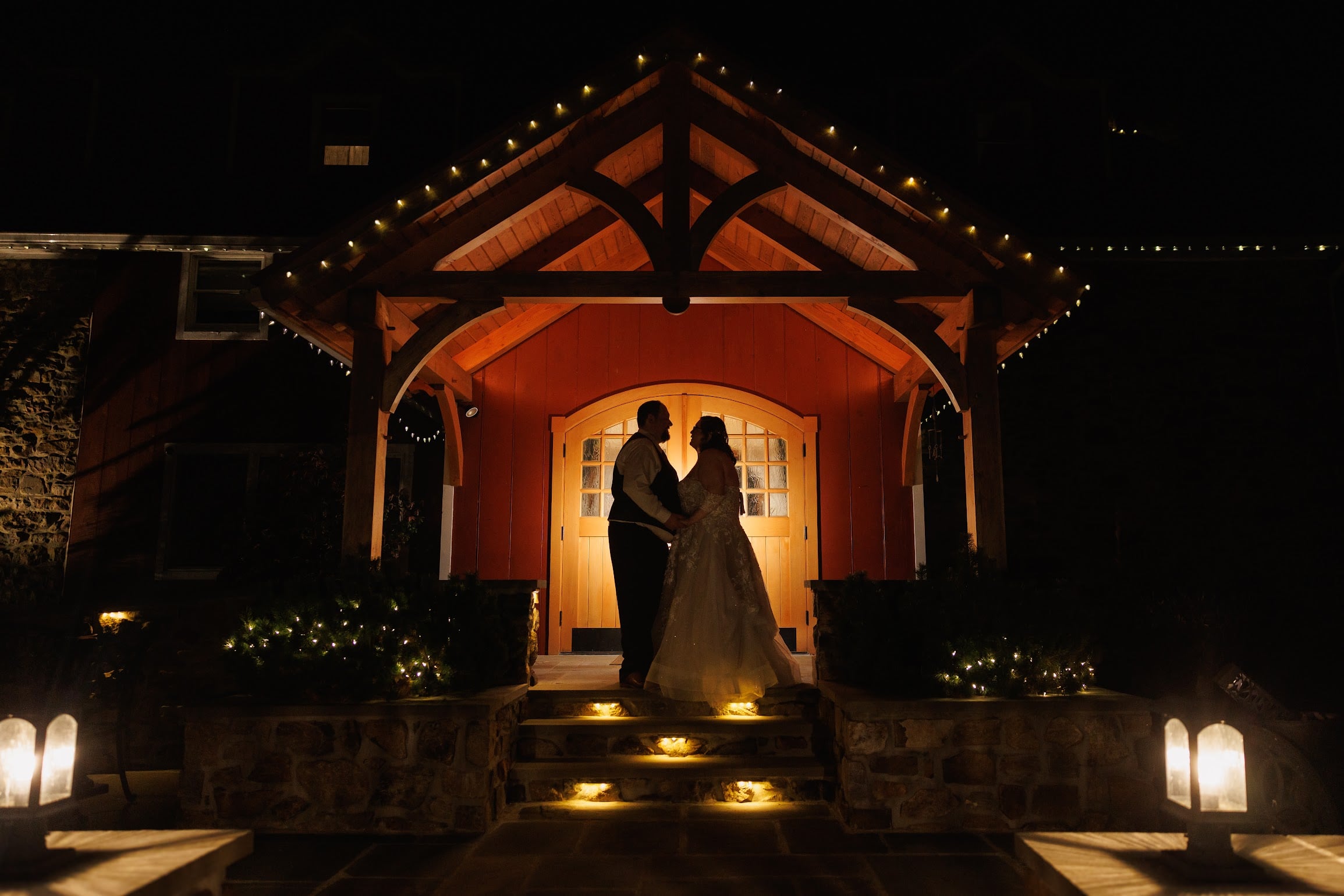 Newlyweds beneath the warmly lit entrance at Bally Spring Inn